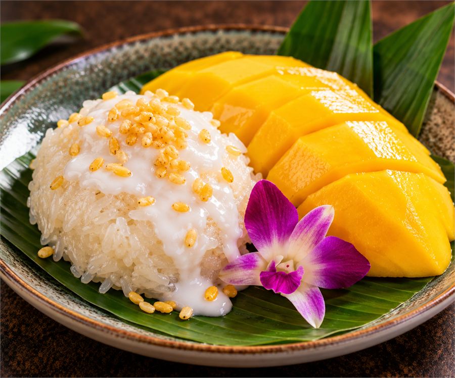Mango with sweet coconut sticky rice and an orchid